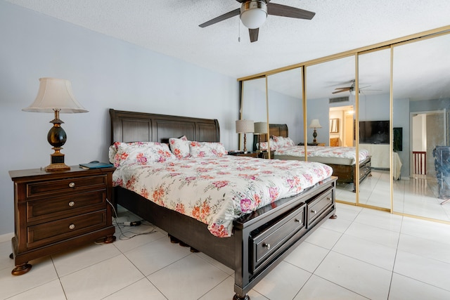 tiled bedroom featuring a textured ceiling, ceiling fan, and a closet