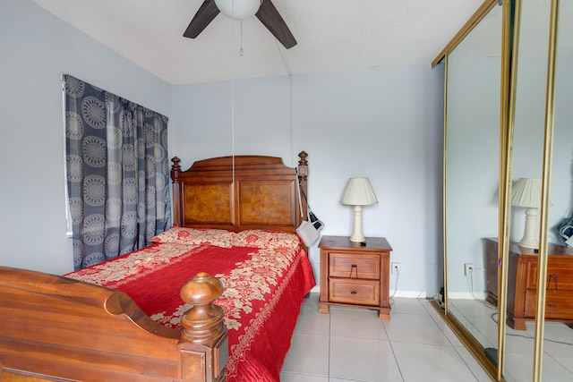 tiled bedroom with a textured ceiling and ceiling fan