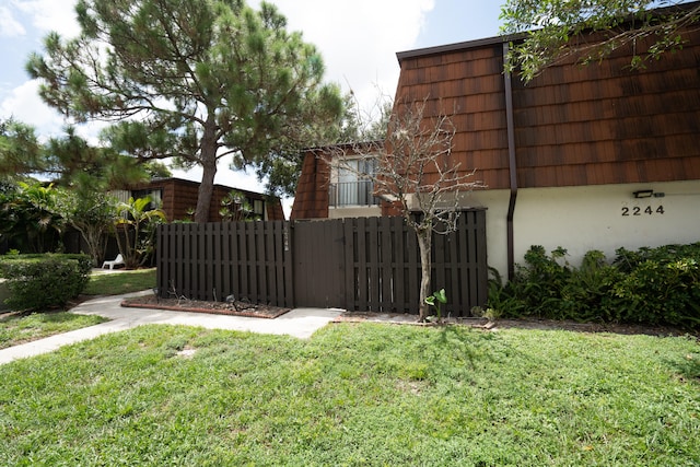 view of gate with a yard