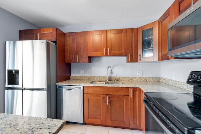 kitchen featuring light stone counters, stainless steel appliances, sink, and light tile patterned floors