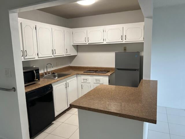 kitchen featuring black appliances, white cabinetry, sink, and light tile patterned floors