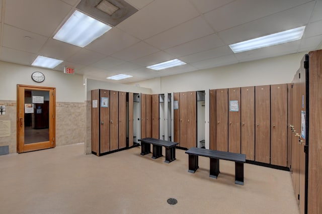 rec room with a paneled ceiling and light colored carpet