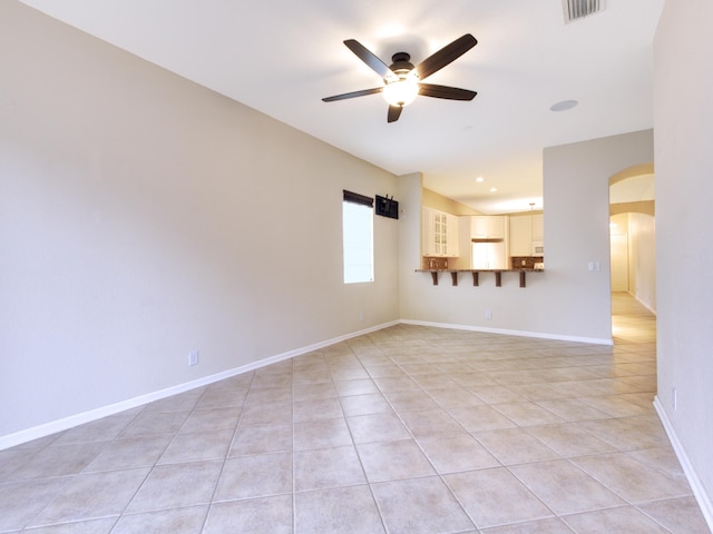 tiled spare room featuring ceiling fan