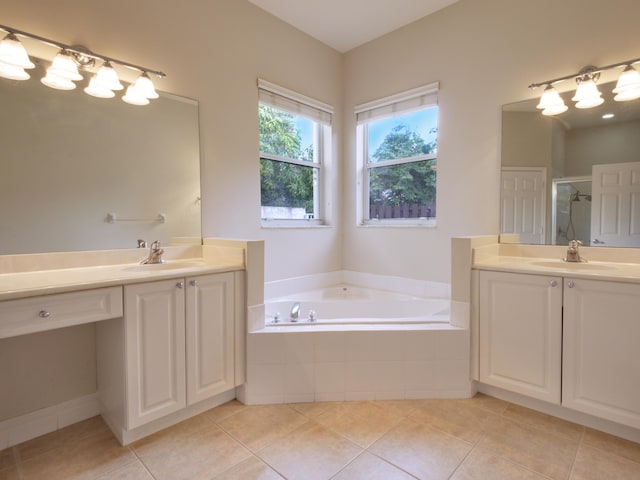 bathroom with tile patterned floors, a relaxing tiled tub, and vanity