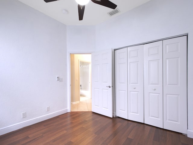 unfurnished bedroom featuring dark tile patterned flooring, a closet, and ceiling fan