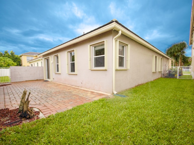 back of property with a patio area and a yard