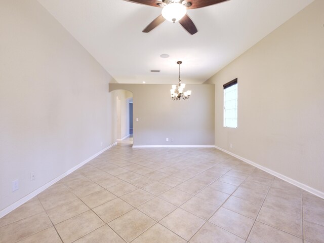 empty room with ceiling fan with notable chandelier and light tile patterned floors