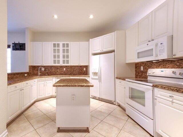 kitchen with a kitchen island, white appliances, decorative backsplash, and light tile patterned floors