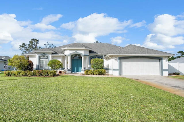 single story home with a garage and a front lawn