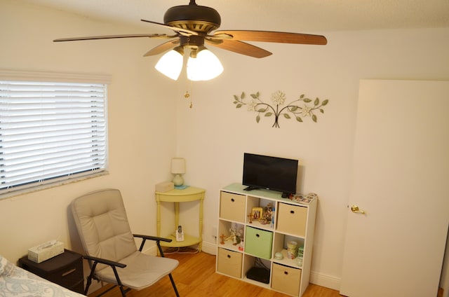 interior space with ceiling fan, vaulted ceiling, and light wood-type flooring