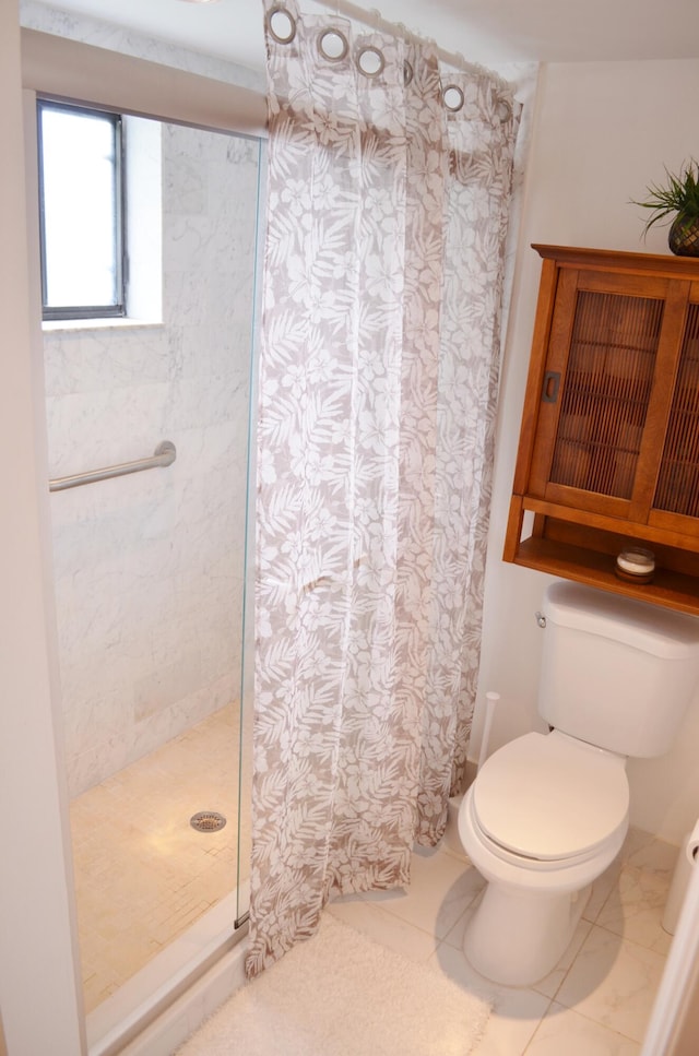 bathroom featuring toilet, a shower with curtain, and tile patterned floors