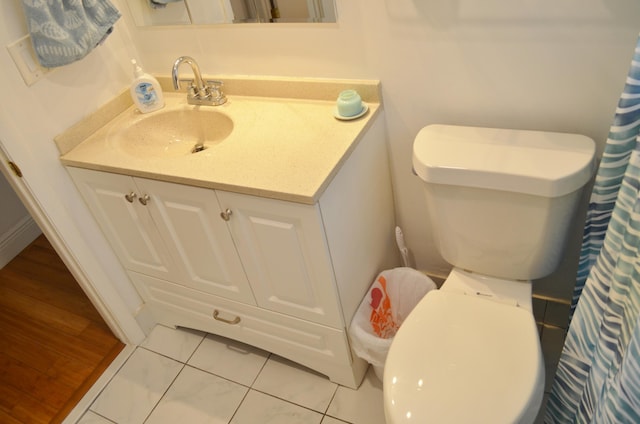 bathroom featuring hardwood / wood-style flooring, toilet, and vanity