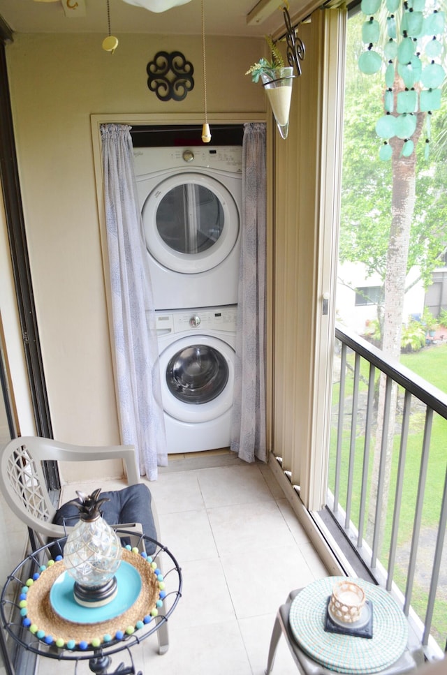 laundry area featuring light tile patterned floors and stacked washer and dryer