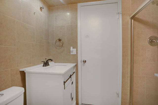 bathroom featuring tile walls, toilet, an enclosed shower, and vanity