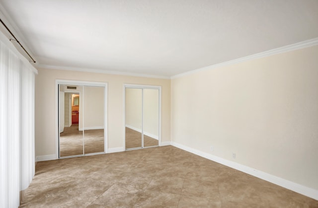 unfurnished bedroom with tile patterned floors, multiple closets, and ornamental molding