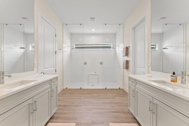 bathroom featuring wood-type flooring, a shower with door, and vanity