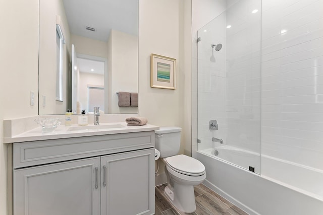 full bathroom with vanity, toilet, tiled shower / bath combo, and hardwood / wood-style flooring