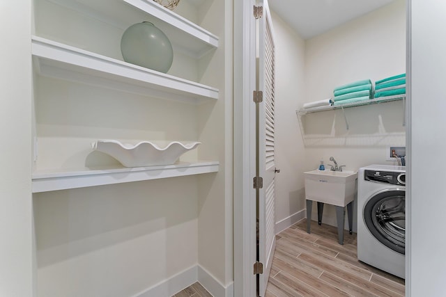 clothes washing area featuring washer / dryer and light wood-type flooring