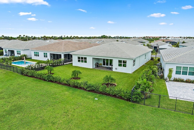 back of house featuring a fenced in pool, a lawn, and a patio