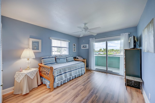 bedroom featuring light hardwood / wood-style floors, access to outside, ceiling fan, and multiple windows