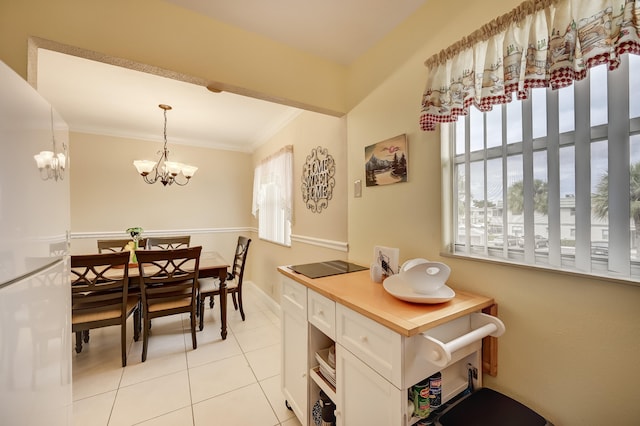 dining space featuring crown molding, an inviting chandelier, and light tile patterned floors