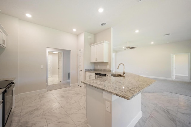 kitchen with sink, ceiling fan, light stone countertops, white cabinetry, and kitchen peninsula