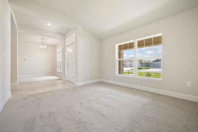 carpeted spare room featuring a chandelier and lofted ceiling