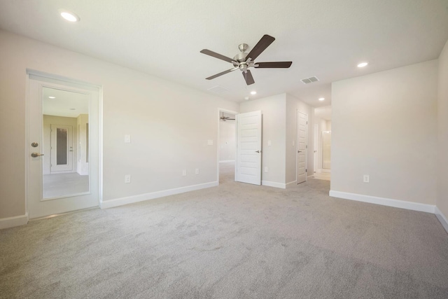 unfurnished bedroom featuring ceiling fan, light colored carpet, and ensuite bathroom