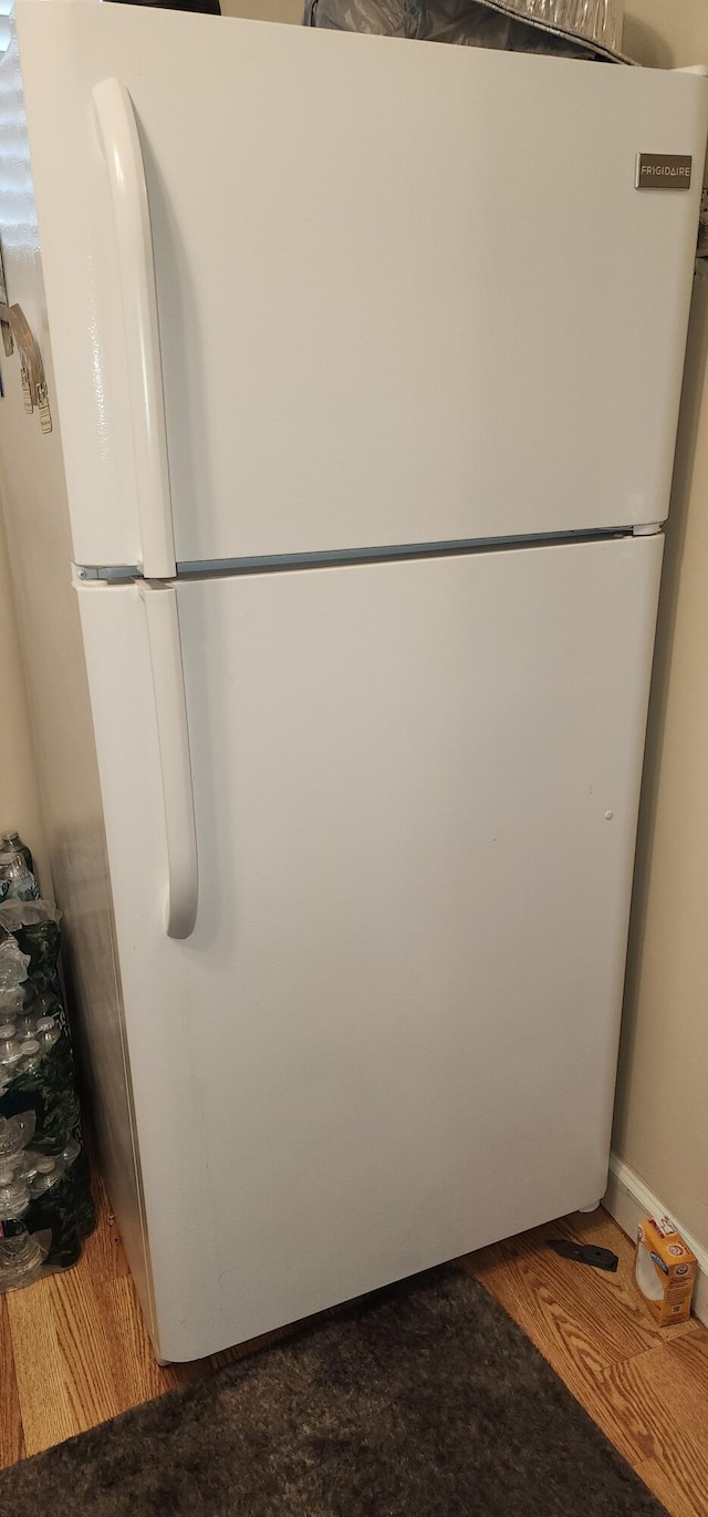 interior details featuring white refrigerator and wood-type flooring