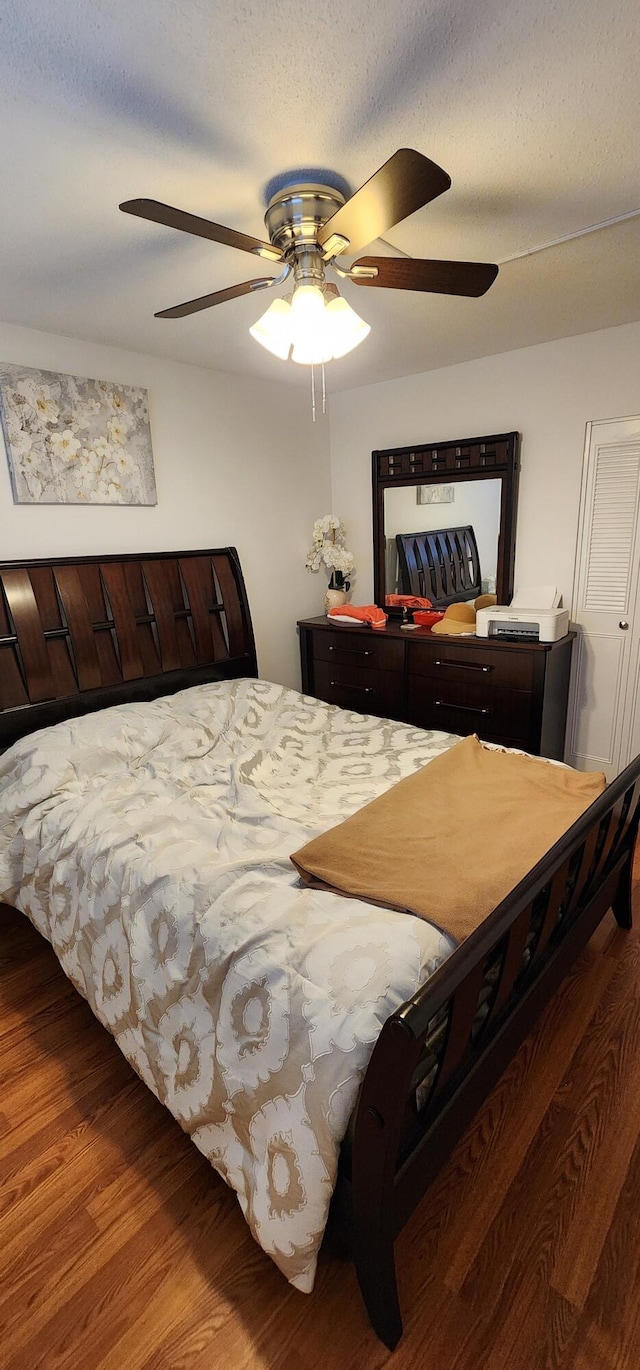 bedroom featuring a textured ceiling, ceiling fan, and hardwood / wood-style flooring