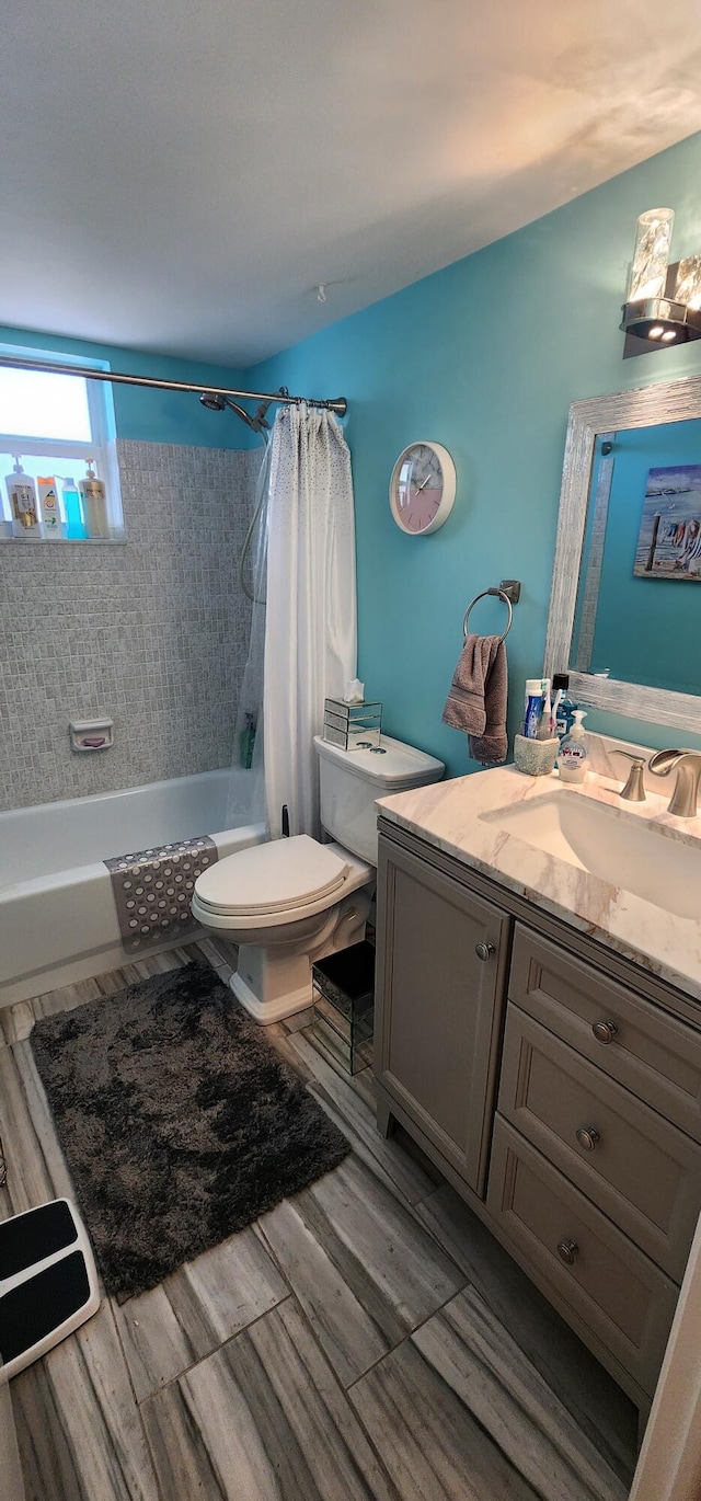 full bathroom with shower / bath combination with curtain, toilet, and vanity