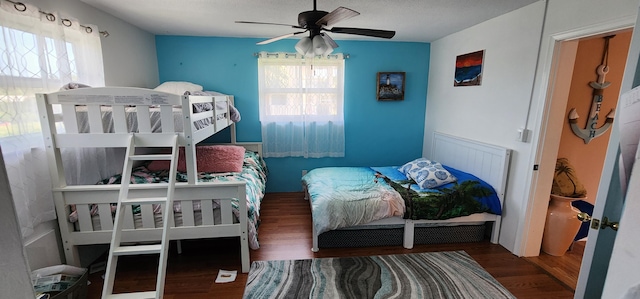 bedroom with ceiling fan, hardwood / wood-style flooring, and multiple windows