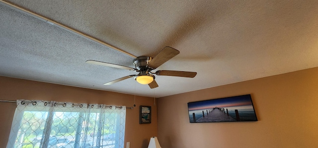 room details with ceiling fan and a textured ceiling