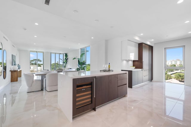 kitchen featuring wine cooler, recessed lighting, light countertops, dark brown cabinets, and modern cabinets