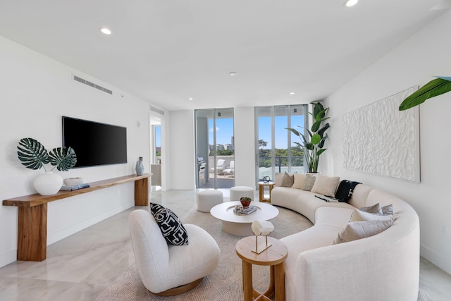 living area featuring baseboards, visible vents, a wall of windows, and recessed lighting