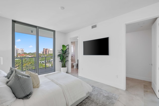 bedroom featuring ensuite bath, baseboards, visible vents, and a wall of windows