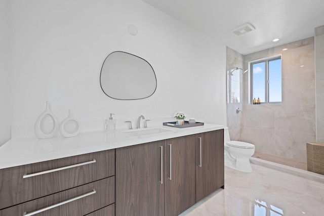 full bath featuring visible vents, tiled shower, toilet, marble finish floor, and vanity