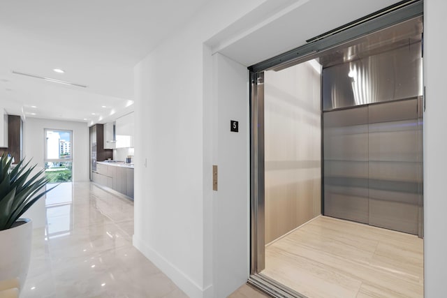 corridor with baseboards, recessed lighting, and elevator