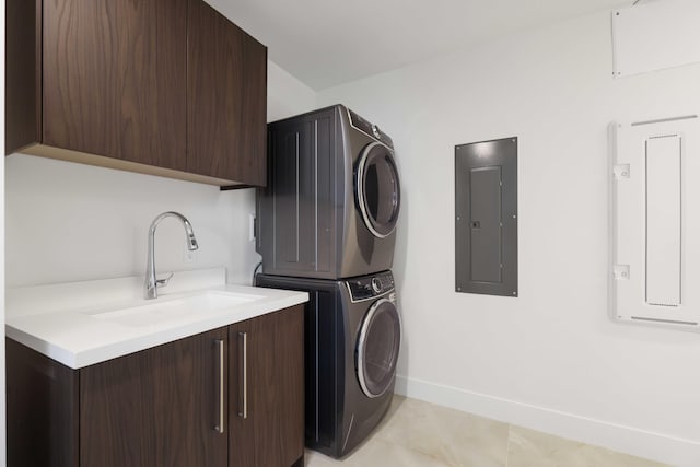 laundry room with light tile patterned flooring, stacked washer and clothes dryer, sink, cabinets, and electric panel