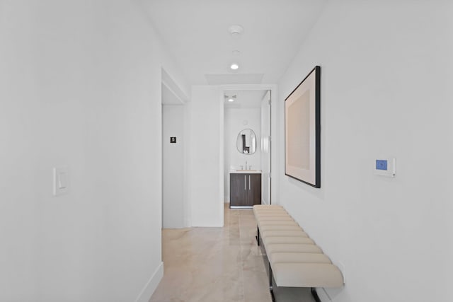 hallway with light tile patterned floors and sink