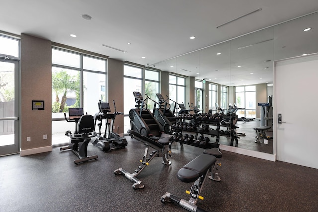 workout area featuring a wall of windows, recessed lighting, and baseboards