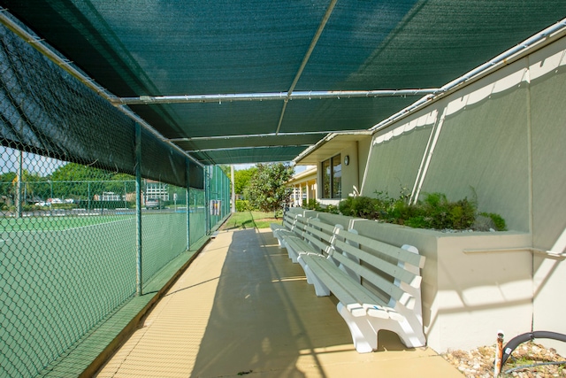 view of home's community featuring tennis court