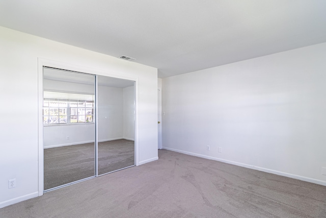 unfurnished bedroom featuring carpet floors and a closet