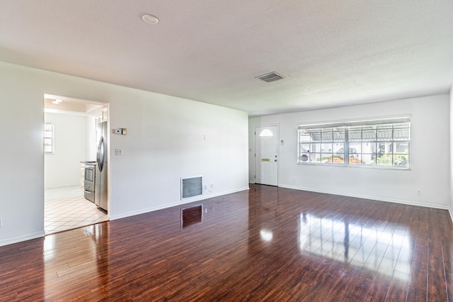 spare room with a textured ceiling and hardwood / wood-style floors