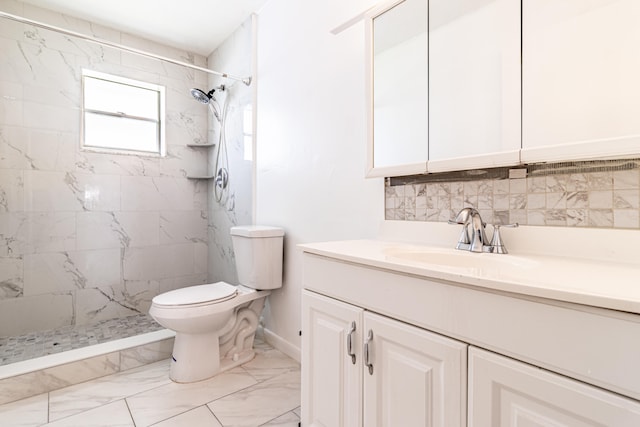 bathroom featuring backsplash, vanity, tile patterned floors, tiled shower, and toilet