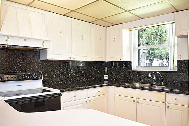 kitchen featuring sink, electric range, white cabinets, and premium range hood