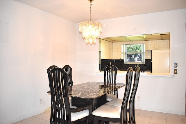 tiled dining area featuring a chandelier