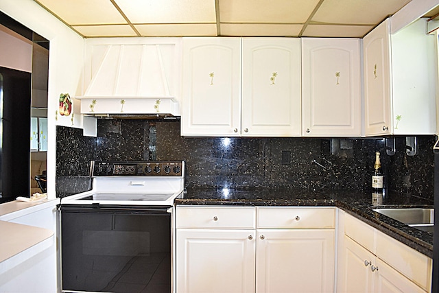 kitchen with dark stone counters, backsplash, electric range, custom exhaust hood, and white cabinets