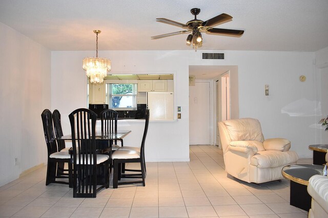 tiled dining space with ceiling fan with notable chandelier