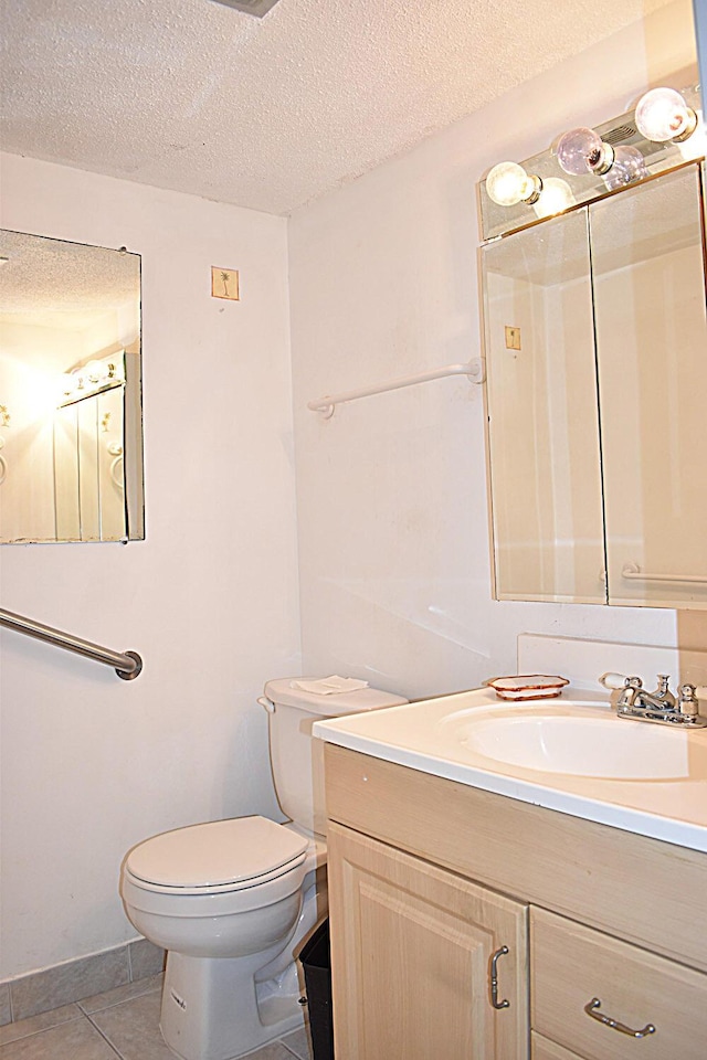 bathroom featuring vanity, tile patterned floors, a textured ceiling, and toilet